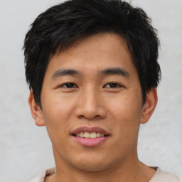 Joyful asian young-adult male with short  brown hair and brown eyes