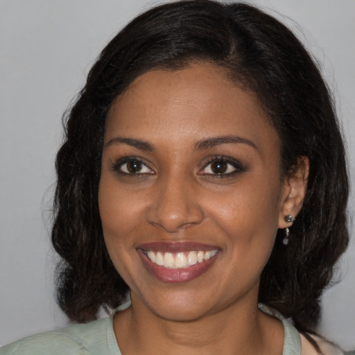 Joyful black young-adult female with medium  brown hair and brown eyes
