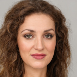 Joyful white young-adult female with long  brown hair and green eyes