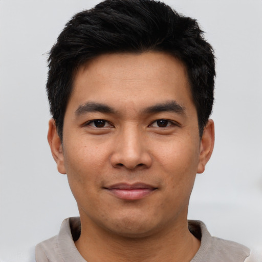 Joyful asian young-adult male with short  black hair and brown eyes