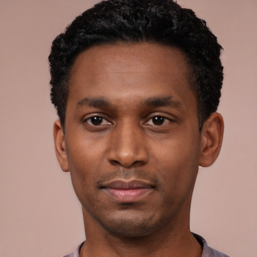 Joyful black young-adult male with short  black hair and brown eyes