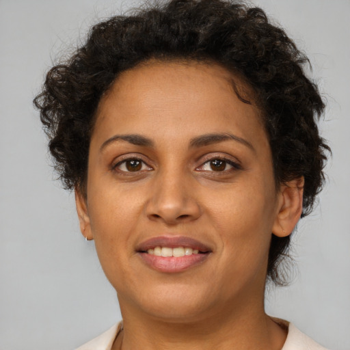Joyful latino young-adult female with short  brown hair and brown eyes