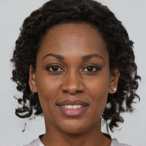 Joyful black adult female with short  brown hair and brown eyes