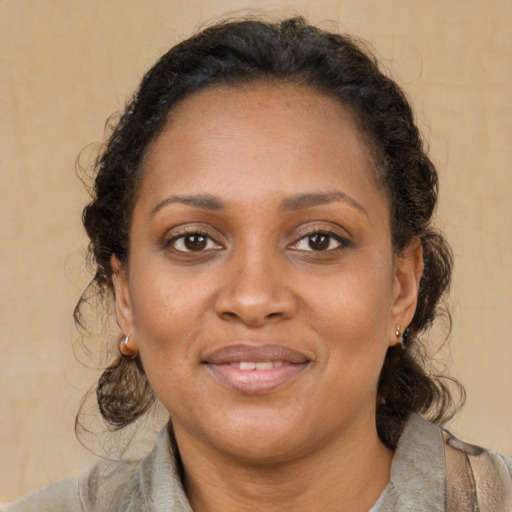 Joyful black adult female with medium  brown hair and brown eyes