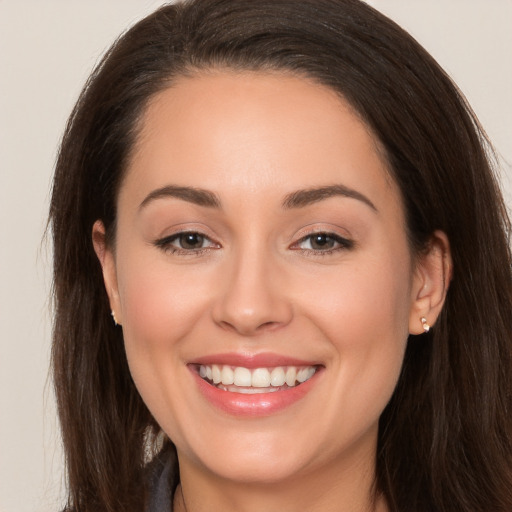 Joyful white young-adult female with long  brown hair and brown eyes