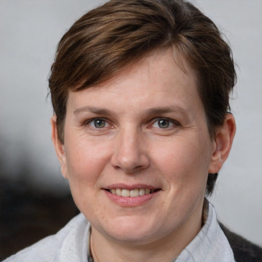 Joyful white adult female with medium  brown hair and grey eyes