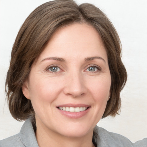 Joyful white adult female with medium  brown hair and grey eyes