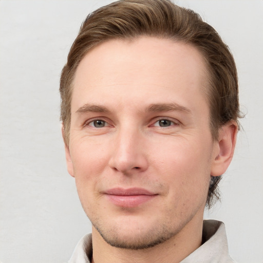 Joyful white young-adult male with short  brown hair and grey eyes