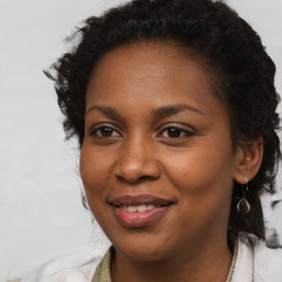 Joyful black young-adult female with long  brown hair and brown eyes