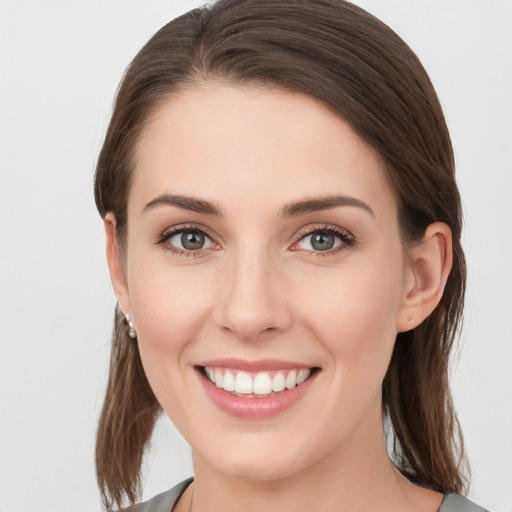 Joyful white young-adult female with medium  brown hair and grey eyes