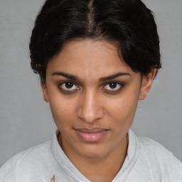 Joyful latino young-adult female with medium  brown hair and brown eyes