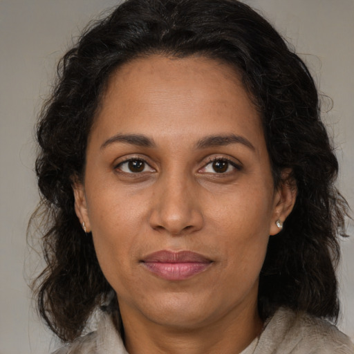 Joyful black adult female with medium  brown hair and brown eyes