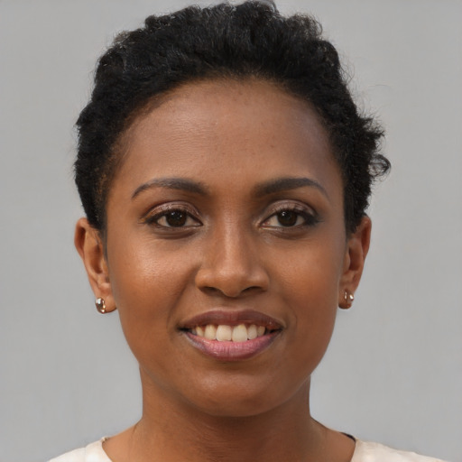 Joyful black young-adult female with short  brown hair and brown eyes