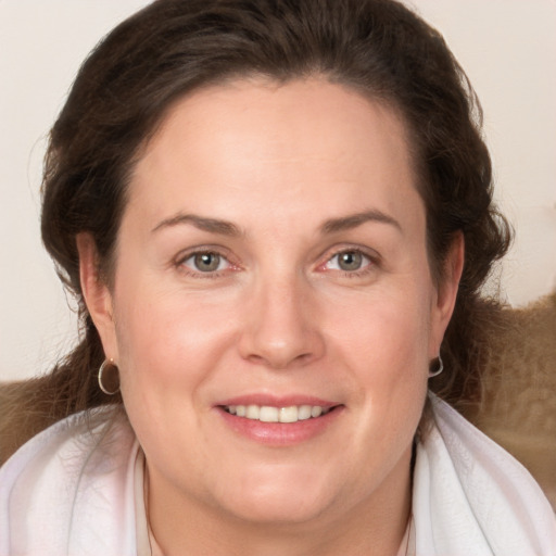 Joyful white adult female with long  brown hair and grey eyes