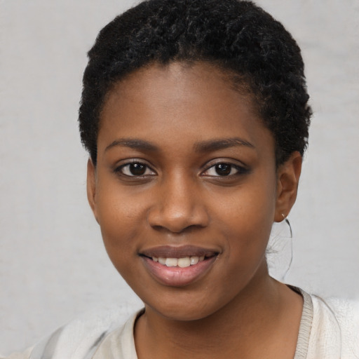 Joyful black young-adult female with short  black hair and brown eyes