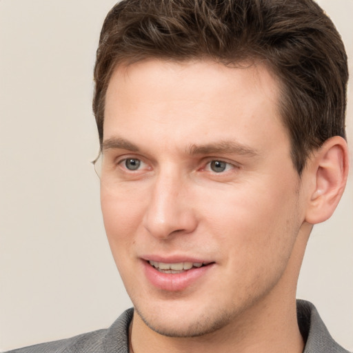 Joyful white young-adult male with short  brown hair and grey eyes