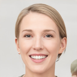 Joyful white young-adult female with medium  brown hair and grey eyes