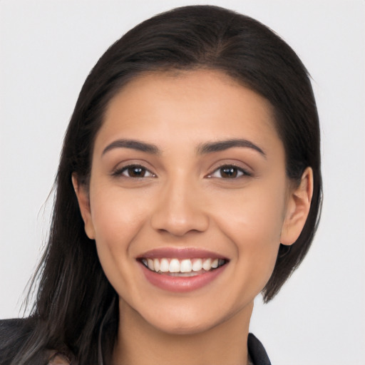 Joyful latino young-adult female with long  brown hair and brown eyes