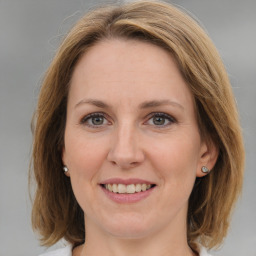 Joyful white adult female with medium  brown hair and grey eyes