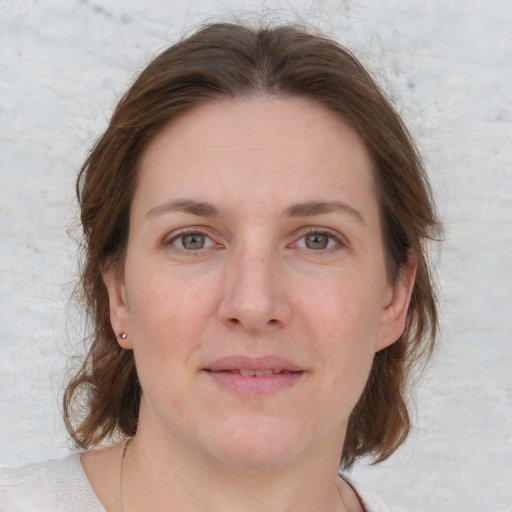 Joyful white adult female with medium  brown hair and grey eyes