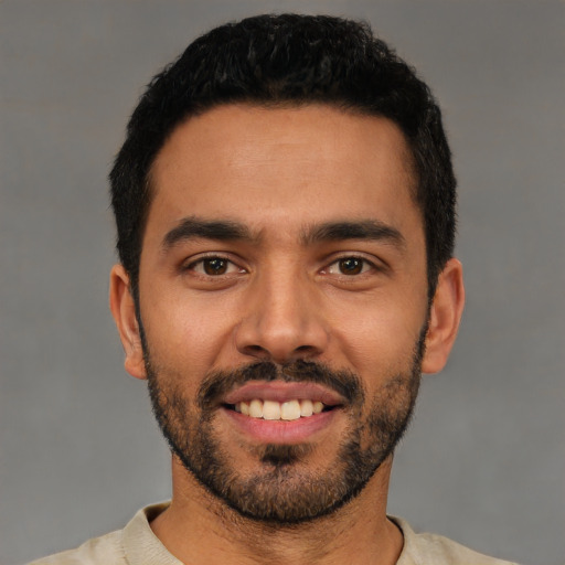 Joyful latino young-adult male with short  black hair and brown eyes