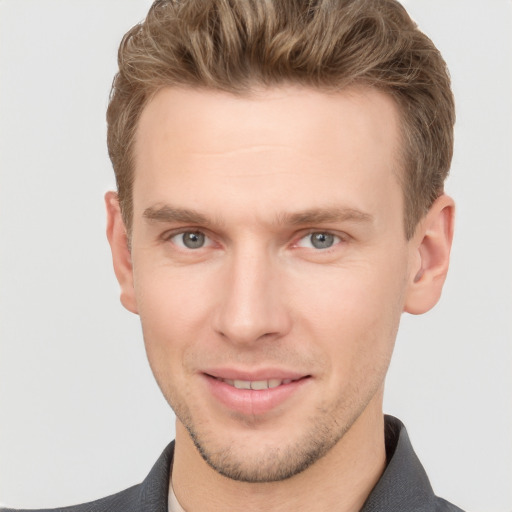 Joyful white young-adult male with short  brown hair and grey eyes