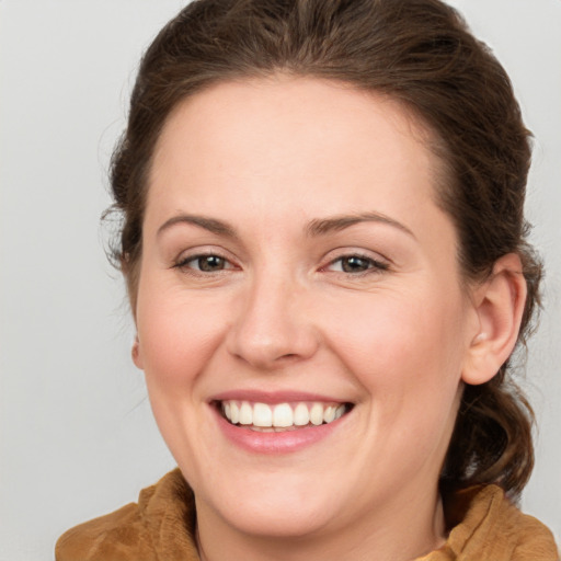 Joyful white young-adult female with medium  brown hair and green eyes