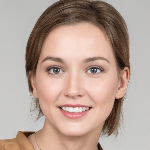 Joyful white young-adult female with medium  brown hair and grey eyes