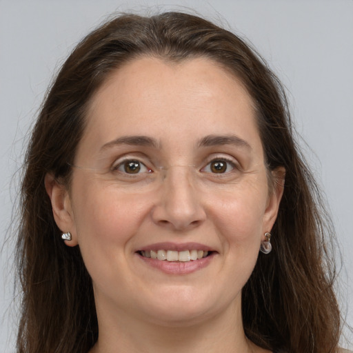 Joyful white adult female with long  brown hair and grey eyes