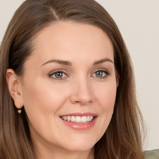 Joyful white young-adult female with long  brown hair and grey eyes