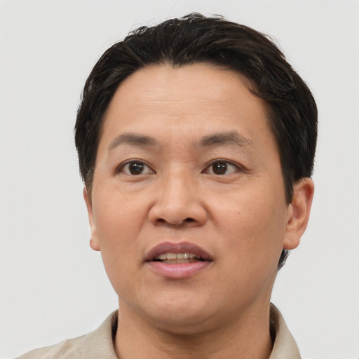Joyful asian adult male with short  brown hair and brown eyes