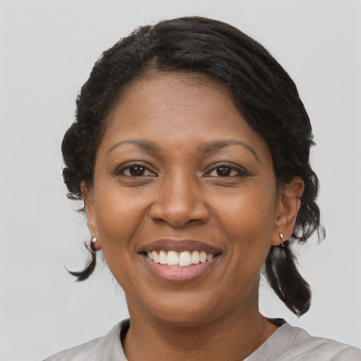 Joyful black adult female with medium  brown hair and brown eyes