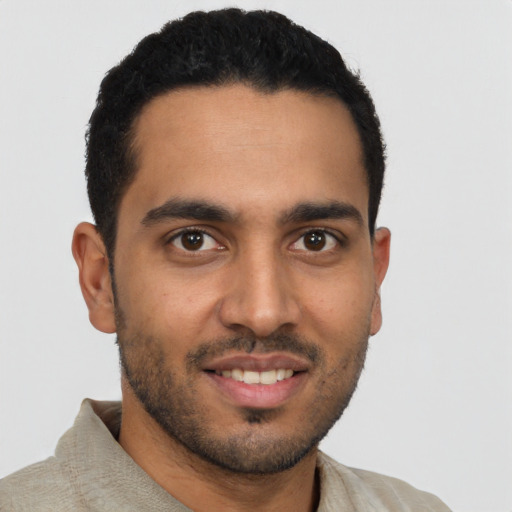 Joyful latino young-adult male with short  brown hair and brown eyes