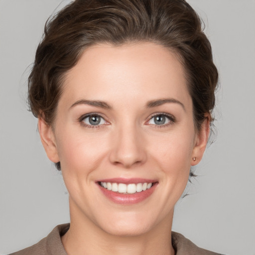 Joyful white young-adult female with short  brown hair and grey eyes