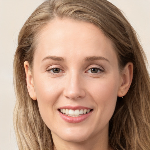 Joyful white young-adult female with long  brown hair and grey eyes