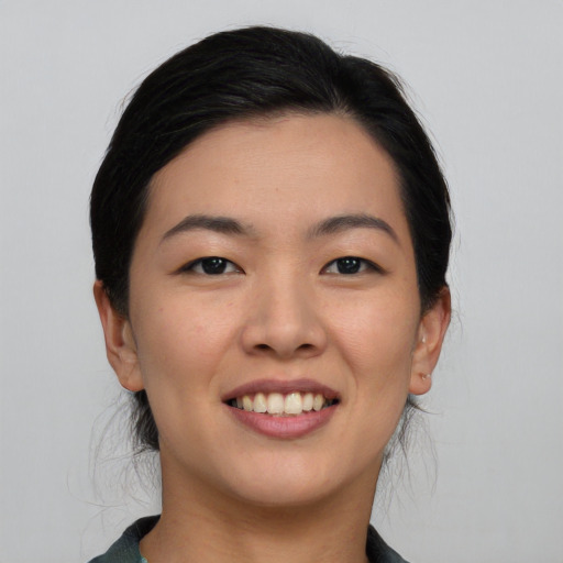 Joyful asian young-adult female with medium  black hair and brown eyes