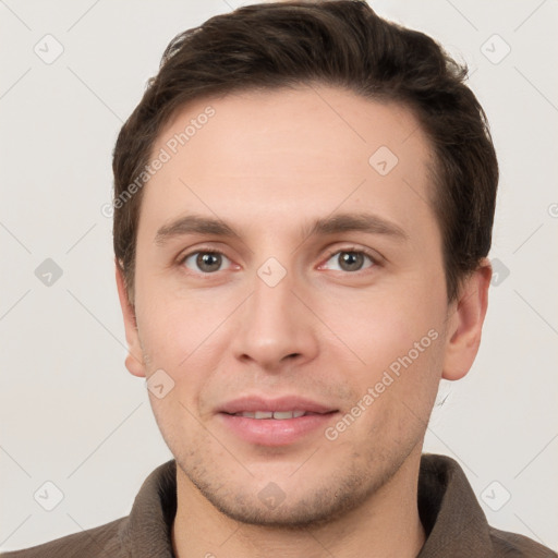 Joyful white young-adult male with short  brown hair and grey eyes