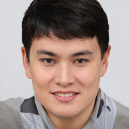 Joyful asian young-adult male with short  brown hair and brown eyes