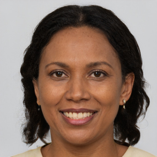 Joyful latino adult female with medium  brown hair and brown eyes