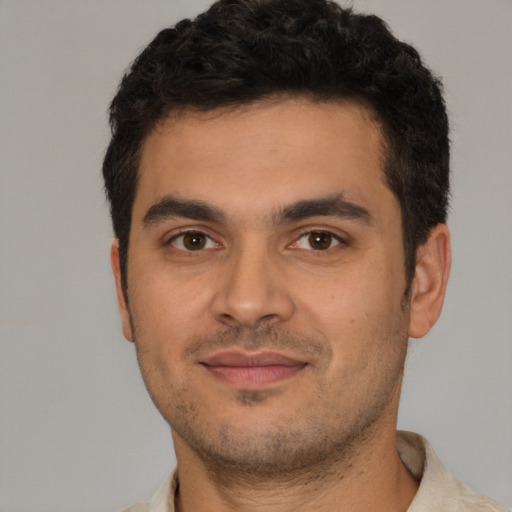 Joyful white young-adult male with short  black hair and brown eyes