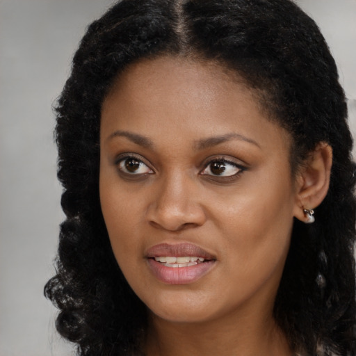 Joyful black young-adult female with long  brown hair and brown eyes