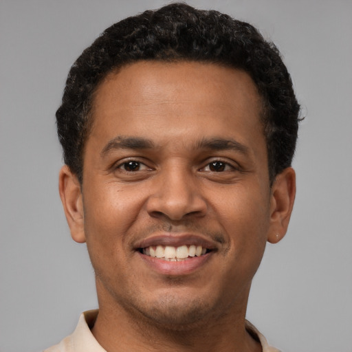Joyful latino young-adult male with short  brown hair and brown eyes