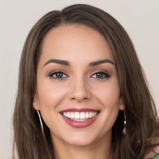 Joyful white young-adult female with long  brown hair and grey eyes