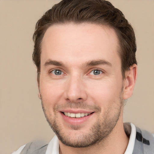 Joyful white young-adult male with short  brown hair and grey eyes