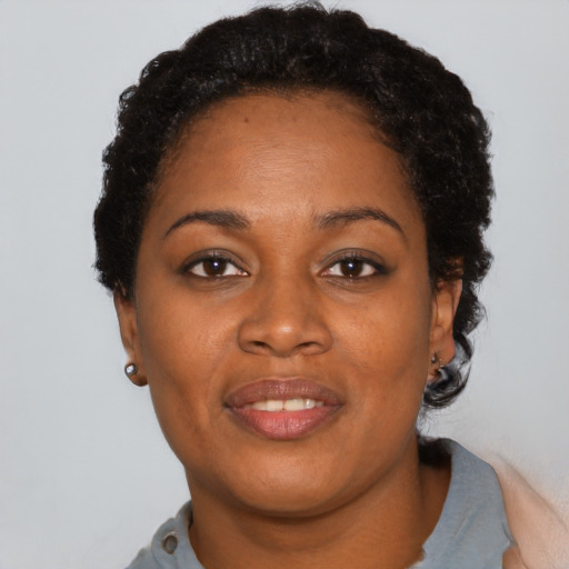 Joyful black adult female with short  brown hair and brown eyes