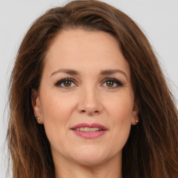 Joyful white adult female with long  brown hair and brown eyes