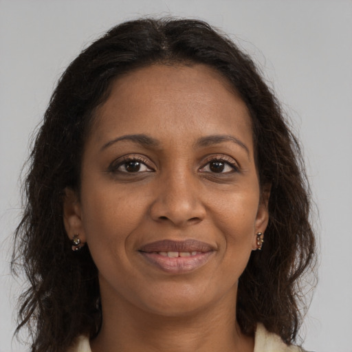 Joyful black adult female with long  brown hair and brown eyes