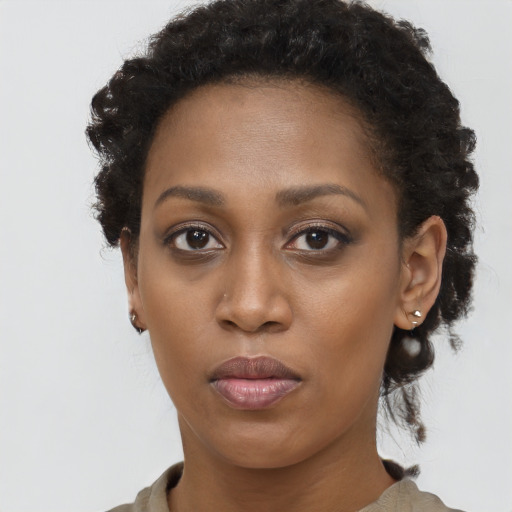 Joyful black young-adult female with long  brown hair and brown eyes
