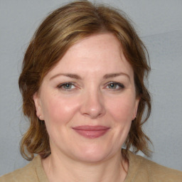 Joyful white adult female with medium  brown hair and blue eyes