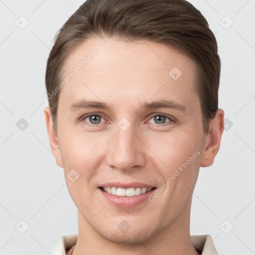 Joyful white young-adult male with short  brown hair and grey eyes